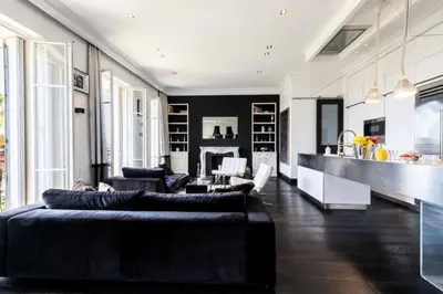 a living room with black and white furniture and a kitchen at Résidence Prestige Et Confort Face Au Palais Des Festivals - Prestige et Confort Face au Palais des Festivals MAE-3173 in Cannes