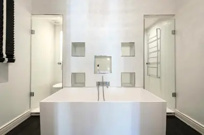 a white tub in a bathroom with two mirrors at Résidence Prestige Et Confort Face Au Palais Des Festivals - Prestige et Confort Face au Palais des Festivals MAE-3173 in Cannes