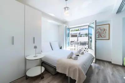 a white bedroom with a bed and a window at Résidence Appartement Lumineux Centre Cannes - Appartement lumineux Centre Cannes MAE-3193 in Cannes