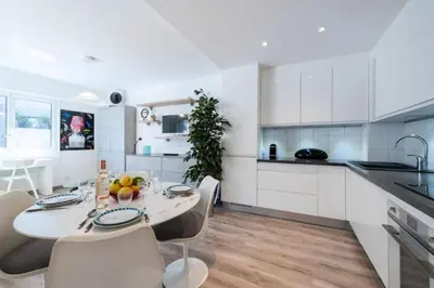 a kitchen with white cabinets and a table and chairs at Résidence Appartement Lumineux Centre Cannes - Appartement lumineux Centre Cannes MAE-3193 in Cannes