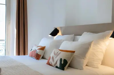 a bedroom with white pillows on a bed with a window at Résidence 3p Terrasse & Calme Cannes Centre - 3P Terrasse & Calme Cannes Centre MAE-3213 in Cannes