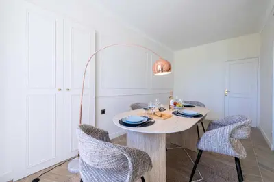 a white dining room with a table and chairs at Résidence 4p Bourgeois Rez-de-jardin, Proche Croisette & Plages - 4P Bourgeois Rez-de-jardin, proche Croisette & Plages MAE-3243 in Cannes