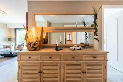 a mirror on top of a wooden dresser in a living room at Résidence 4p Piscine Privée & Vue Mer - 4P Piscine privée & Vue mer MAE-3263 in Cannes
