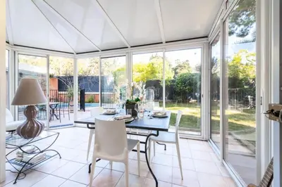 a dining room with a table and chairs and windows at Résidence 4p Piscine Privée & Vue Mer - 4P Piscine privée & Vue mer MAE-3263 in Cannes