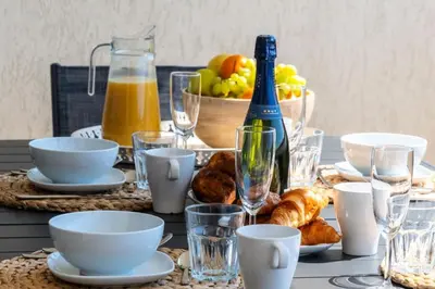 a table with a plate of food and a bottle of wine at Résidence 3p Vue Mer, Piscine – Cannes Croix Des Gardes - 3P Vue Mer, Piscine – Cannes Croix des Gardes MAE-3273 in Cannes
