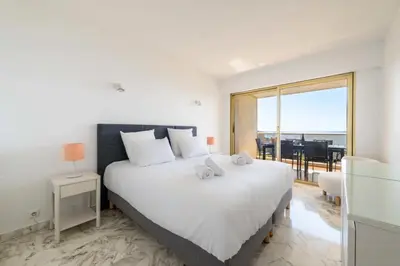 a bedroom with a large white bed and a large window at Résidence 3p Vue Mer, Piscine – Cannes Croix Des Gardes - 3P Vue Mer, Piscine – Cannes Croix des Gardes MAE-3273 in Cannes