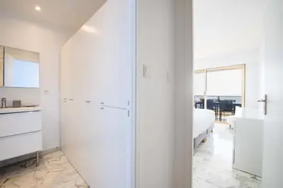 a white bedroom with a bed and a glass door at Résidence 3p Vue Mer, Piscine – Cannes Croix Des Gardes - 3P Vue Mer, Piscine – Cannes Croix des Gardes MAE-3273 in Cannes