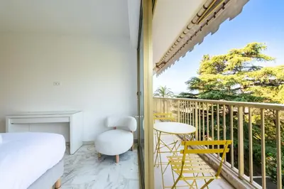 a bedroom with a balcony with a bed and a table and chairs at Résidence 3p Vue Mer, Piscine – Cannes Croix Des Gardes - 3P Vue Mer, Piscine – Cannes Croix des Gardes MAE-3273 in Cannes