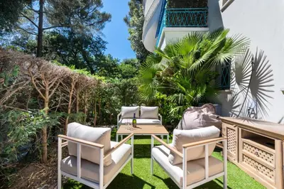 a patio with chairs and a table on the grass at Résidence 2p Rez-de-jardin Au Calme – Cadre Paisible - 2P Rez-de-jardin au calme – Cadre Paisible MAE-3313 in Cannes