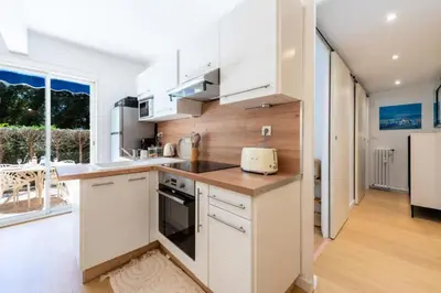 a kitchen with white cabinets and a counter at Résidence 2p Rez-de-jardin Au Calme – Cadre Paisible - 2P Rez-de-jardin au calme – Cadre Paisible MAE-3313 in Cannes