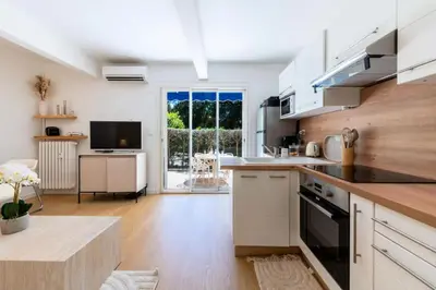 a kitchen with white cabinets and a large window at Résidence 2p Rez-de-jardin Au Calme – Cadre Paisible - 2P Rez-de-jardin au calme – Cadre Paisible MAE-3313 in Cannes