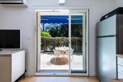 a kitchen with a sliding glass door leading to a patio at Résidence 2p Rez-de-jardin Au Calme – Cadre Paisible - 2P Rez-de-jardin au calme – Cadre Paisible MAE-3313 in Cannes
