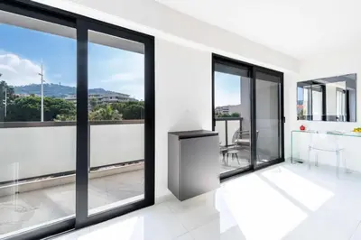 a room with glass windows and a kitchen with a view at Résidence 2p Traversant, Centre Cannes, Rue D’antibes - 2P Traversant, Centre Cannes, Rue d’Antibes MAE-3343 in Cannes