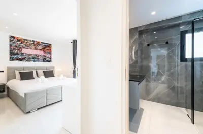a white bedroom with a bed and a shower at Résidence 2p Traversant, Centre Cannes, Rue D’antibes - 2P Traversant, Centre Cannes, Rue d’Antibes MAE-3343 in Cannes