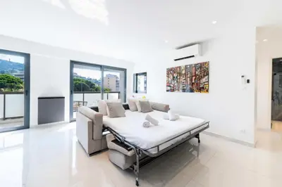 a white room with a bed and a couch at Résidence 2p Traversant, Centre Cannes, Rue D’antibes - 2P Traversant, Centre Cannes, Rue d’Antibes MAE-3343 in Cannes