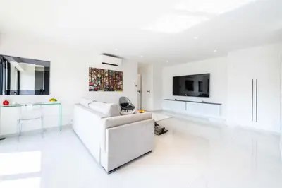a white living room with a white couch and a tv at Résidence 2p Traversant, Centre Cannes, Rue D’antibes - 2P Traversant, Centre Cannes, Rue d’Antibes MAE-3343 in Cannes