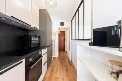 a kitchen with white cabinets and black appliances at Résidence 2p Terrasse – Palm Beach, Proche Plages - 2P Terrasse – Palm Beach, Proche Plages MAE-2753 in Cannes