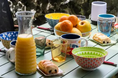 a table topped with cups and bowls of orange juice at Résidence 2p Terrasse – Palm Beach, Proche Plages - 2P Terrasse – Palm Beach, Proche Plages MAE-2753 in Cannes