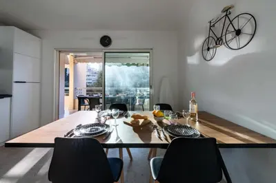 a dining room with a table and a bike hanging on the wall at Résidence 3p Résidence Avec Piscine, Proche Croisette - 3P Résidence avec piscine, proche Croisette MAE-2773 in Cannes