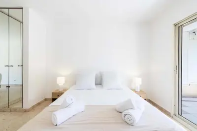 a white bedroom with a large bed with towels on it at Résidence 3p Résidence Avec Piscine, Proche Croisette - 3P Résidence avec piscine, proche Croisette MAE-2773 in Cannes