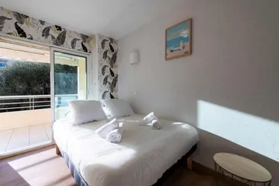 a white bed in a room with a large window at Résidence 3p Résidence Avec Piscine, Proche Croisette - 3P Résidence avec piscine, proche Croisette MAE-2773 in Cannes