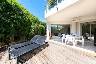 a wooden deck with a table and chairs on a house at Résidence 2p Rez-de-jardin Avec Piscine – Calme, Parking Privé - 2P Rez-de-jardin avec piscine – Calme, Parking privé MAE-2133 in Cannes