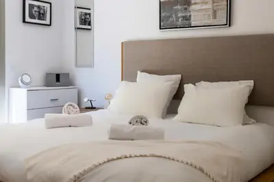 a large white bed with white pillows on it at Résidence 2p Rez-de-jardin Avec Piscine – Calme, Parking Privé - 2P Rez-de-jardin avec piscine – Calme, Parking privé MAE-2133 in Cannes