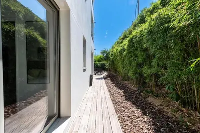 a wooden walkway next to a white building at Résidence 2p Rez-de-jardin Avec Piscine – Calme, Parking Privé - 2P Rez-de-jardin avec piscine – Calme, Parking privé MAE-2133 in Cannes