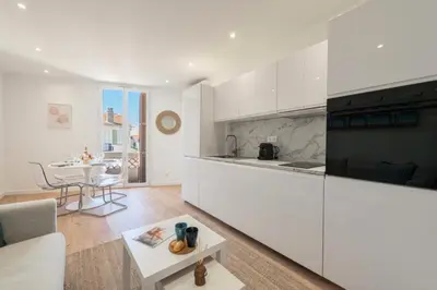 a kitchen with white cabinets and a table at Résidence Cannes 2p Proche Centre - Cannes 2P Proche Centre MAE-4093 in Cannes