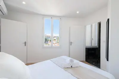 a white bedroom with a bed with a towel on it at Résidence Cannes 2p Proche Centre - Cannes 2P Proche Centre MAE-4093 in Cannes