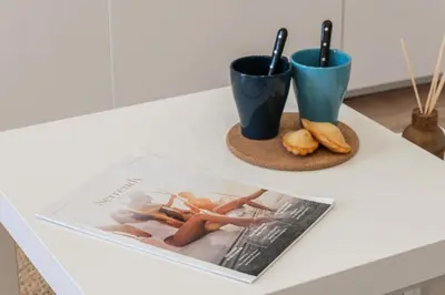 a table with two cups and a magazine on it at Résidence Cannes 2p Proche Centre - Cannes 2P Proche Centre MAE-4093 in Cannes