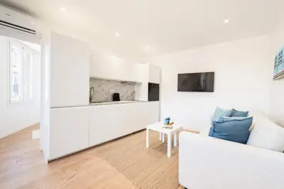 a white living room with a couch and a table at Résidence Cannes 2p Proche Centre - Cannes 2P Proche Centre MAE-4093 in Cannes