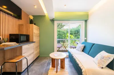 a living room with a blue couch and a tv at Résidence 2p Au Calme, Proche Plages Et Centre Ville - 2P au Calme, proche Plages et Centre ville MAE-5693 in Cannes