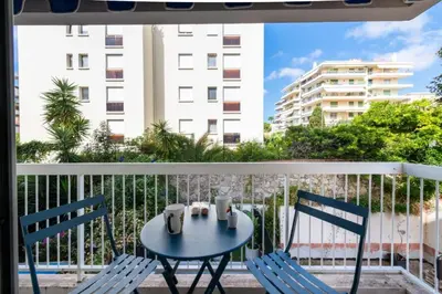 a table and chairs on a balcony with a view of a building at Résidence 2p Au Calme, Proche Plages Et Centre Ville - 2P au Calme, proche Plages et Centre ville MAE-5693 in Cannes