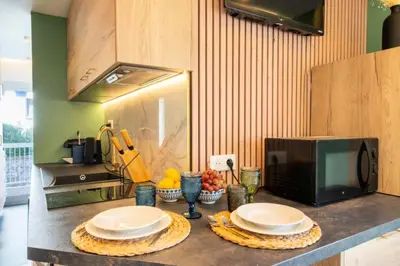 a kitchen with a counter with plates and a microwave at Résidence 2p Au Calme, Proche Plages Et Centre Ville - 2P au Calme, proche Plages et Centre ville MAE-5693 in Cannes