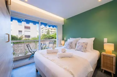 a bedroom with a large bed and a large window at Résidence 2p Au Calme, Proche Plages Et Centre Ville - 2P au Calme, proche Plages et Centre ville MAE-5693 in Cannes