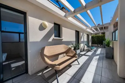 a balcony with a wicker chair and a glass roof at Résidence 4p Rooftop Avec Jacuzzi & Parking, Cannes - 4P Rooftop avec Jacuzzi & Parking, Cannes MAE-7563 in Cannes