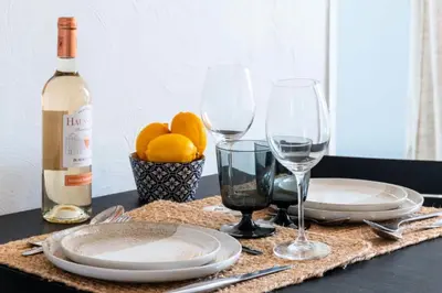 a table with plates and glasses and a bottle of wine at Résidence Studio Dernier étage – Cœur De Cannes - Studio dernier étage – Cœur de Cannes MAE-4493 in Cannes