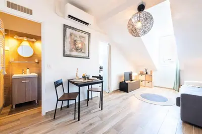 a living room with a table and chairs in a room at Résidence Studio Dernier étage – Cœur De Cannes - Studio dernier étage – Cœur de Cannes MAE-4493 in Cannes