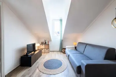 a living room with a blue couch and a television at Résidence Studio Dernier étage – Cœur De Cannes - Studio dernier étage – Cœur de Cannes MAE-4493 in Cannes