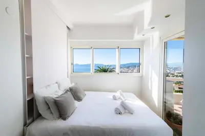 a white bedroom with a white bed with a window at Résidence 3p Vue Panoramique - Dernier Étage, Cannes - 3P Vue Panoramique - Dernier Étage, Cannes MAE-3933 in Cannes
