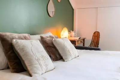 a bedroom with a white bed with pillows and a table at Résidence Studio Dernier étage – Centre Cannes - Studio dernier étage – Centre Cannes MAE-3943 in Cannes