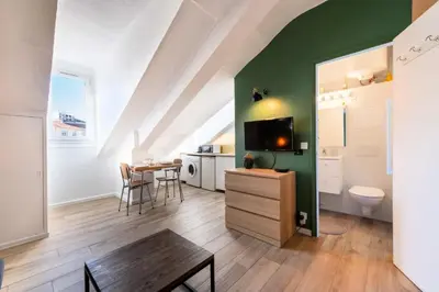 a living room with a green wall and a table at Résidence Studio Dernier étage – Centre Cannes - Studio dernier étage – Centre Cannes MAE-3943 in Cannes