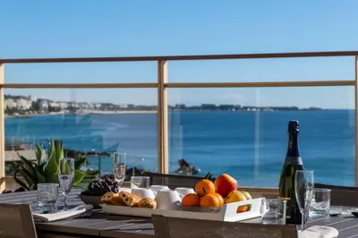 a table with a plate of fruit and a bottle of wine at Résidence 3p Vue Panoramique & Accès Plages - 3P Vue Panoramique & Accès Plages MAE-5013 in Cannes