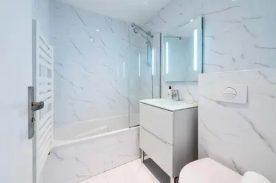 a white bathroom with a shower and a sink at Résidence 3p Vue Panoramique & Accès Plages - 3P Vue Panoramique & Accès Plages MAE-5013 in Cannes