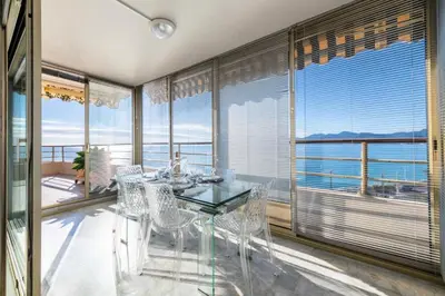 a dining room with a glass table and views of the ocean at Résidence 3p Vue Panoramique & Accès Plages - 3P Vue Panoramique & Accès Plages MAE-5013 in Cannes