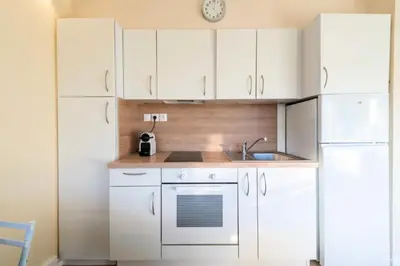 a kitchen with white cabinets and a sink and a refrigerator at Résidence 2p Proche Plage Et Croisette, Palm Beach - 2P Proche Plage et Croisette, Palm Beach MAE-2193 in Cannes