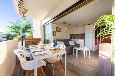 a kitchen and living room with a table and chairs at Résidence 2p Proche Plage Et Croisette, Palm Beach - 2P Proche Plage et Croisette, Palm Beach MAE-2193 in Cannes