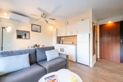 a living room with a couch and a kitchen at Résidence 2p Proche Plage Et Croisette, Palm Beach - 2P Proche Plage et Croisette, Palm Beach MAE-2193 in Cannes