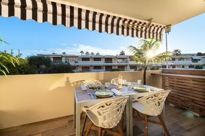 a dining table on a balcony with a view of a building at Résidence 2p Proche Plage Et Croisette, Palm Beach - 2P Proche Plage et Croisette, Palm Beach MAE-2193 in Cannes